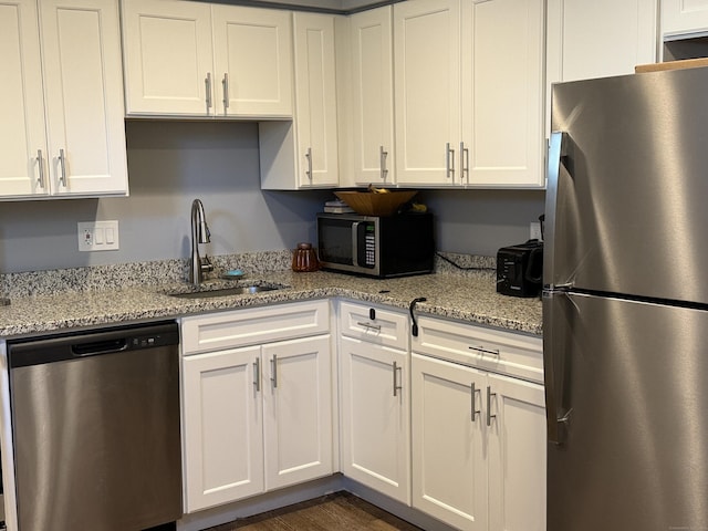 71 Aiken St Apt N7, Norwalk, CT 06851 - kitchen with appliances with stainless steel finishes, white cabinets, and light stone counters