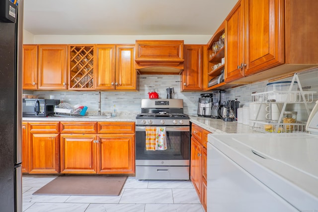51 Park Ave Unit 2-13, Danbury, CT 06810 - kitchen featuring stainless steel appliances, backsplash, light marble finish floors, and washer / clothes dryer