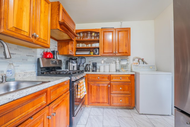 51 Park Ave Unit 2-13, Danbury, CT 06810 - kitchen with washer / clothes dryer, stainless steel range with gas cooktop, custom exhaust hood, and brown cabinets