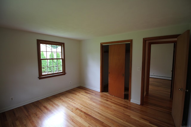 15 Birch Rd, Granby, CT 06035 - unfurnished bedroom with light wood-type flooring, a baseboard heating unit, and a closet
