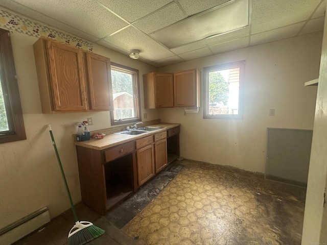 117 State Ave, Killingly, CT 06241 - kitchen with baseboard heating, a paneled ceiling, light countertops, and brown cabinets
