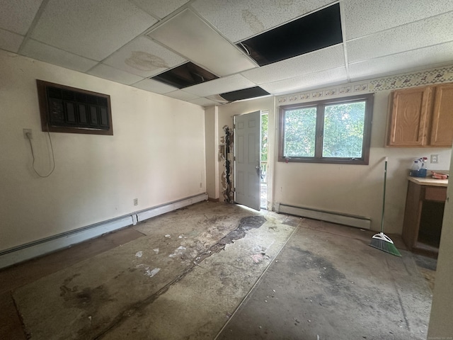 117 State Ave, Killingly, CT 06241 - below grade area featuring baseboard heating, a paneled ceiling, and a wall mounted air conditioner