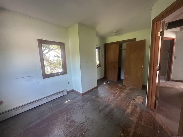 117 State Ave, Killingly, CT 06241 - unfurnished bedroom featuring a baseboard heating unit, a closet, and dark wood-style floors