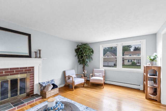 45 Neelans Rd, Enfield, CT 06082 - sitting room featuring a baseboard heating unit, wood finished floors, and a brick fireplace