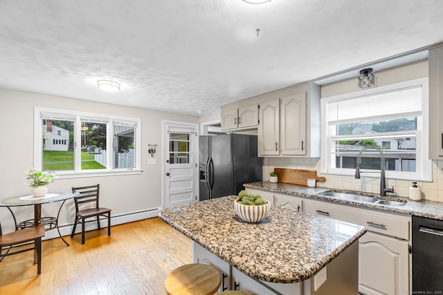 45 Neelans Rd, Enfield, CT 06082 - kitchen with black appliances, decorative backsplash, light wood-style flooring, a kitchen island, and light stone counters