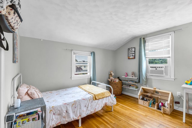 45 Neelans Rd, Enfield, CT 06082 - bedroom with cooling unit, multiple windows, vaulted ceiling, wood finished floors, and a textured ceiling