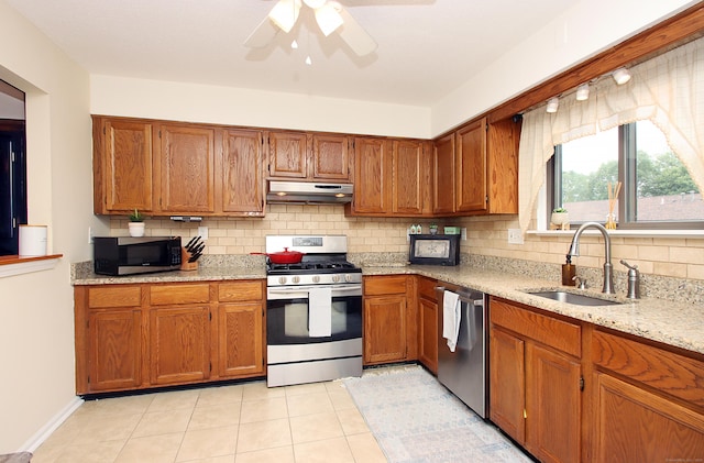 140 Thompson St Apt 16A, East Haven, CT 06513 - kitchen with stainless steel appliances, under cabinet range hood, brown cabinetry, and tasteful backsplash