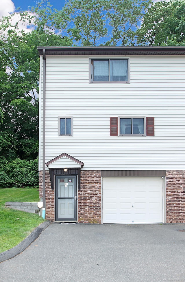 140 Thompson St Apt 16A, East Haven, CT 06513 - view of front of property featuring brick siding, an attached garage, and asphalt driveway