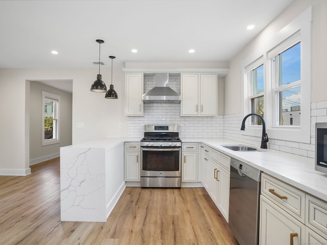 8 Platt St, Norwalk, CT 06855 - kitchen with stainless steel appliances, wall chimney range hood, a peninsula, light wood-style floors, and tasteful backsplash