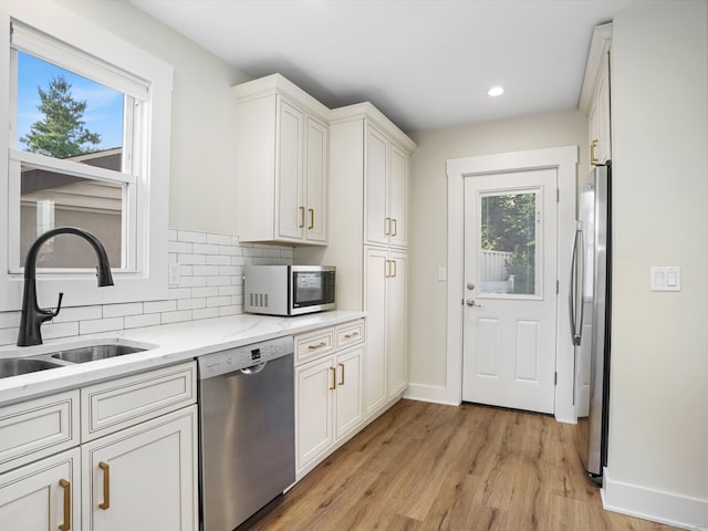 8 Platt St, Norwalk, CT 06855 - kitchen with stainless steel appliances, light wood-type flooring, backsplash, recessed lighting, and light stone counters
