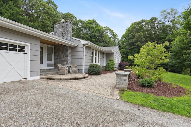 40 Chestnut Ln, Hamden, CT 06518 - view of patio with a garage, driveway, and view of scattered trees
