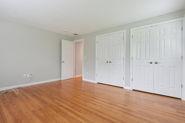 40 Chestnut Ln, Hamden, CT 06518 - unfurnished bedroom featuring two closets and light wood finished floors