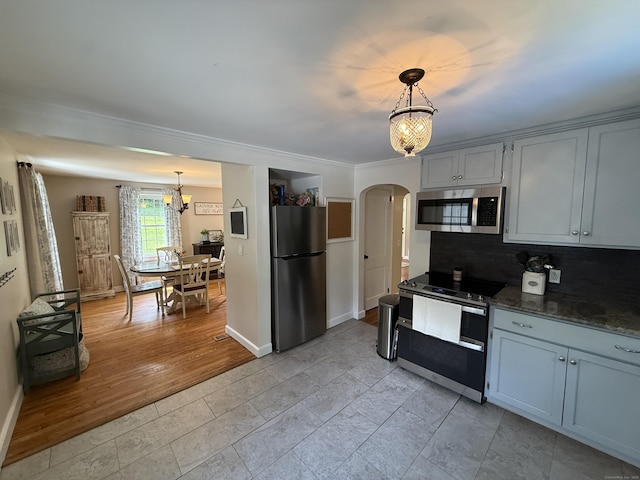 104 Wildcat Hill Rd, Harwinton, CT 06791 - kitchen featuring appliances with stainless steel finishes, arched walkways, tasteful backsplash, ornamental molding, and a chandelier