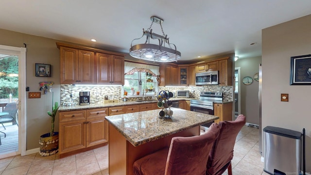 345 Goodwin St, East Hartford, CT 06108 - kitchen with stainless steel appliances, healthy amount of natural light, brown cabinetry, backsplash, and recessed lighting