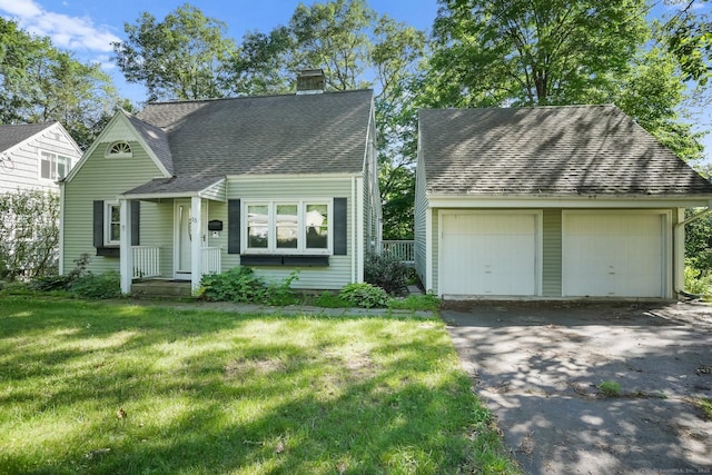 15 Granite Ter, Ansonia, CT 06401 - view of front of house featuring a chimney, an outbuilding, a front yard, roof with shingles, and a detached garage