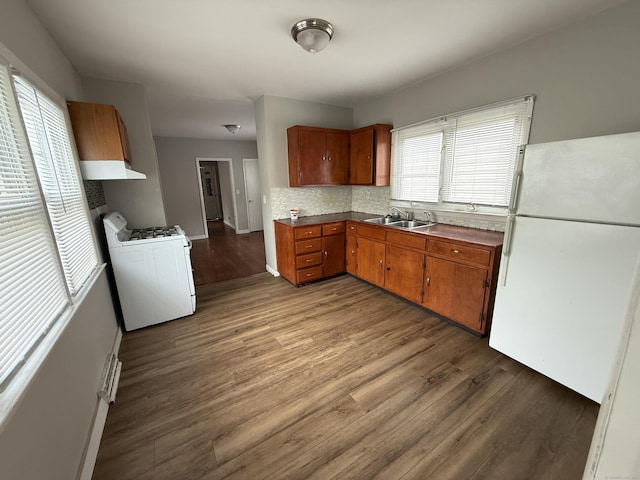 118 Cherry Ann St, New Haven, CT 06514 - kitchen featuring white appliances, custom range hood, brown cabinetry, dark wood-style floors, and decorative backsplash