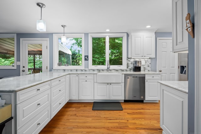 212 Richards Ave Apt 6, Norwalk, CT 06850 - kitchen featuring dishwasher, white cabinetry, a peninsula, decorative light fixtures, and backsplash