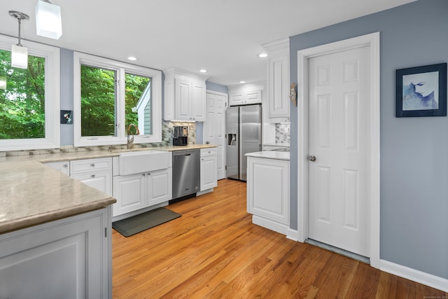 212 Richards Ave Apt 6, Norwalk, CT 06850 - kitchen featuring stainless steel appliances, backsplash, light countertops, white cabinets, and light wood-style floors