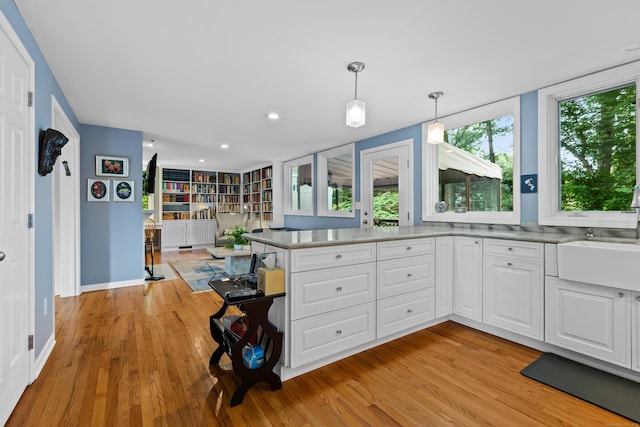 212 Richards Ave Apt 6, Norwalk, CT 06850 - kitchen with light wood-style floors, white cabinetry, a peninsula, hanging light fixtures, and recessed lighting