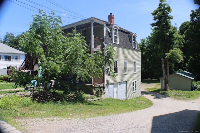 51 Main St, Thompson, CT 06255 - view of home's exterior with a chimney, a balcony, asphalt driveway, and roof with shingles