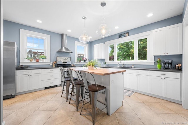 20 Channing St, New London, CT 06320 - kitchen with wall chimney range hood, stainless steel appliances, wooden counters, plenty of natural light, and recessed lighting
