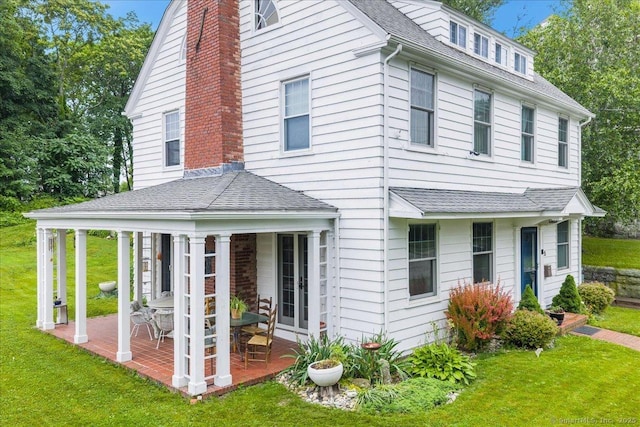 20 Channing St, New London, CT 06320 - view of front facade featuring a patio area, a front lawn, a chimney, and roof with shingles