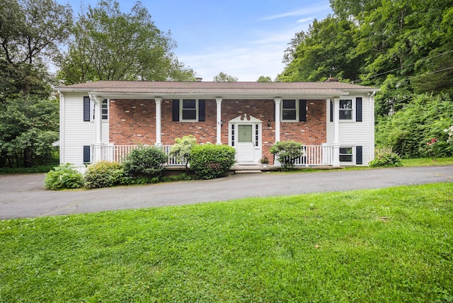 205 Luther Dr, Southbury, CT 06488 - bi-level home featuring a porch, a front yard, and brick siding