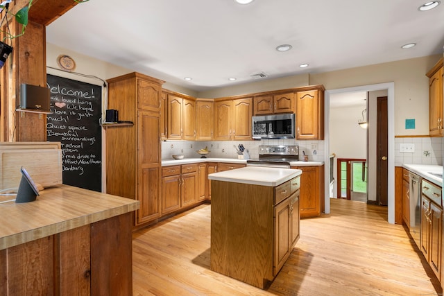 205 Luther Dr, Southbury, CT 06488 - kitchen with stainless steel appliances, light wood finished floors, light countertops, tasteful backsplash, and a kitchen island