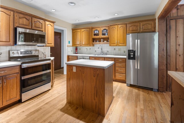 205 Luther Dr, Southbury, CT 06488 - kitchen with appliances with stainless steel finishes, brown cabinetry, light wood-style floors, backsplash, and light countertops