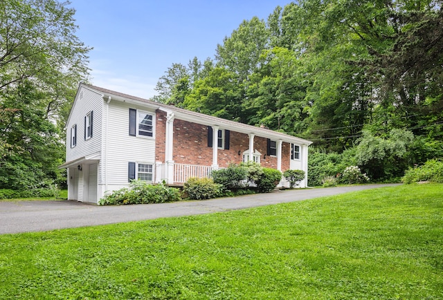 205 Luther Dr, Southbury, CT 06488 - view of front of house featuring a front lawn, asphalt driveway, and brick siding