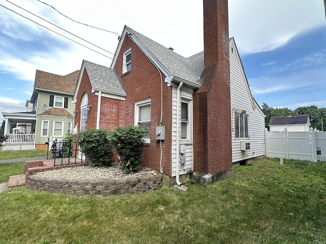 27 Woodbridge Ave, East Hartford, CT 06108 - view of side of home with a chimney, brick siding, cooling unit, and a shingled roof