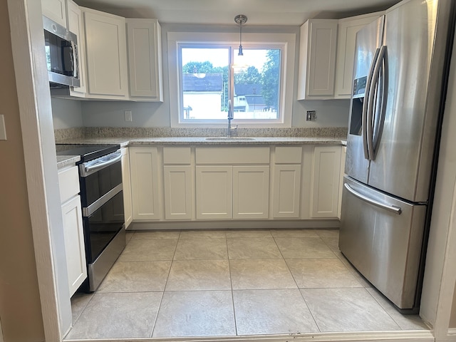 27 Woodbridge Ave, East Hartford, CT 06108 - kitchen with stainless steel appliances, white cabinetry, light tile patterned floors, and pendant lighting