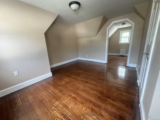 27 Woodbridge Ave, East Hartford, CT 06108 - bonus room with radiator heating unit, vaulted ceiling, and dark wood-style flooring