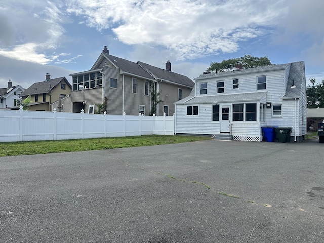 27 Woodbridge Ave, East Hartford, CT 06108 - rear view of house featuring entry steps, a residential view, a shingled roof, and a chimney