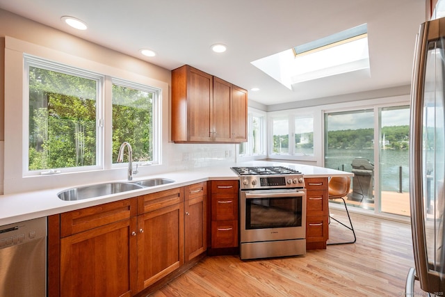 100 N Lake Shore Dr, Brookfield, CT 06804 - kitchen with appliances with stainless steel finishes, a skylight, light wood-style floors, light countertops, and recessed lighting