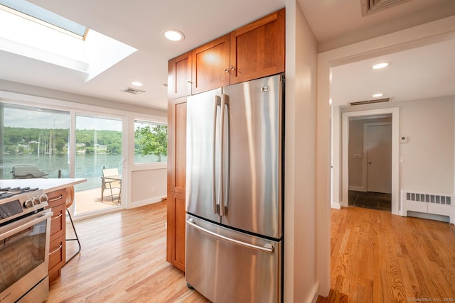 100 N Lake Shore Dr, Brookfield, CT 06804 - kitchen with appliances with stainless steel finishes, a skylight, light wood-style floors, recessed lighting, and brown cabinetry