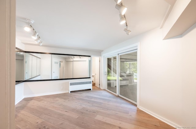 100 N Lake Shore Dr, Brookfield, CT 06804 - spare room featuring radiator heating unit, track lighting, and hardwood / wood-style flooring
