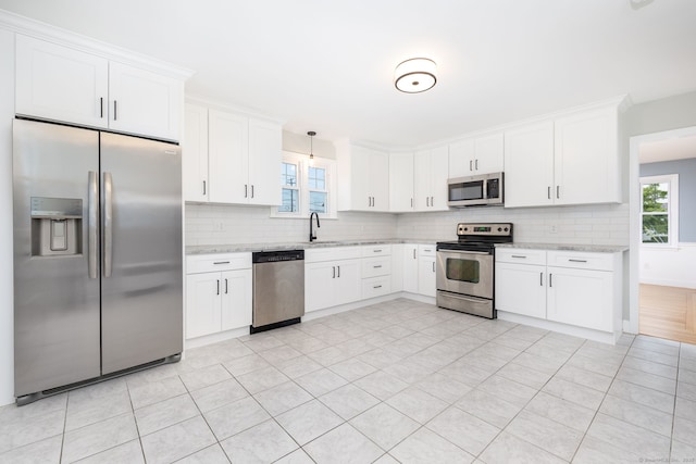 19 Robert St, Hamden, CT 06514 - kitchen with appliances with stainless steel finishes, decorative backsplash, white cabinetry, and light stone counters