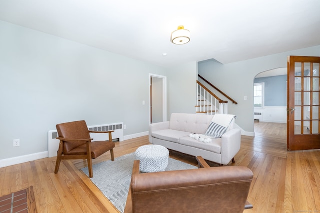 19 Robert St, Hamden, CT 06514 - living room featuring radiator, arched walkways, and light wood-style floors