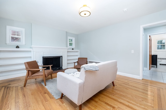 19 Robert St, Hamden, CT 06514 - living area featuring radiator, light wood-style flooring, and a brick fireplace