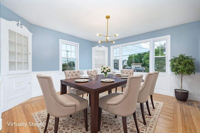 19 Robert St, Hamden, CT 06514 - dining space featuring a chandelier, a wainscoted wall, light wood-type flooring, and a decorative wall
