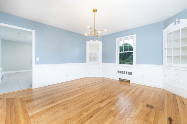 19 Robert St, Hamden, CT 06514 - unfurnished dining area with radiator heating unit, a wainscoted wall, a chandelier, and wood finished floors