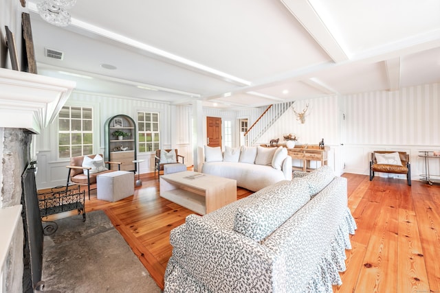 509 Main St N, Woodbury, CT 06798 - living area featuring hardwood / wood-style flooring, a decorative wall, beamed ceiling, a premium fireplace, and stairs