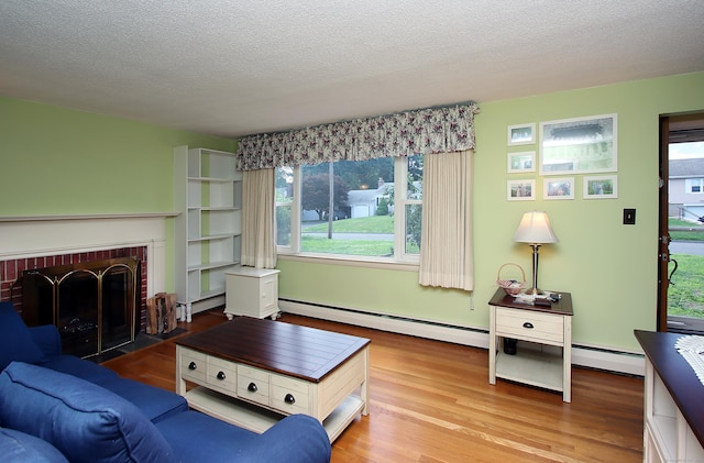 134 Valley Crest Dr, Wethersfield, CT 06109 - living room with baseboard heating, wood finished floors, a fireplace, and a textured ceiling