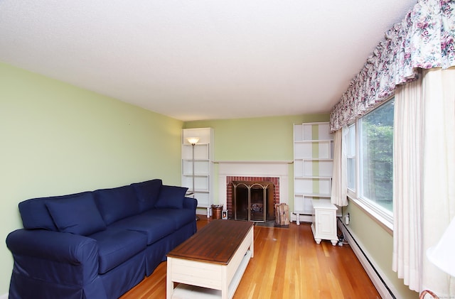 134 Valley Crest Dr, Wethersfield, CT 06109 - living room with baseboard heating, light wood finished floors, a baseboard radiator, and a fireplace