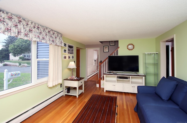 134 Valley Crest Dr, Wethersfield, CT 06109 - living room featuring baseboard heating, wood finished floors, healthy amount of natural light, stairway, and a textured ceiling