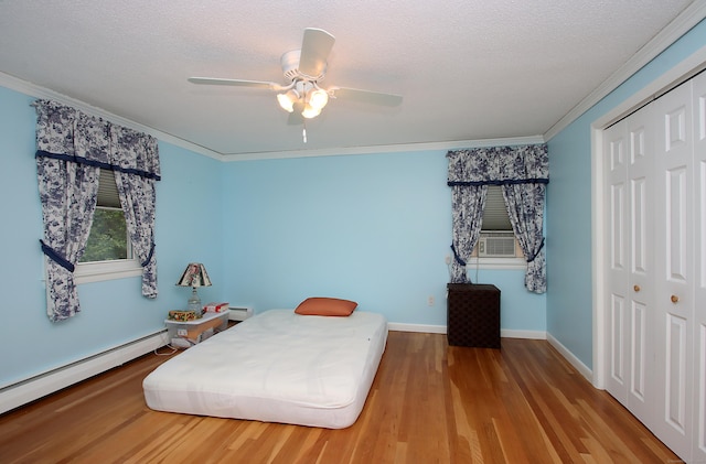 134 Valley Crest Dr, Wethersfield, CT 06109 - bedroom featuring ornamental molding, baseboard heating, wood finished floors, a closet, and a ceiling fan