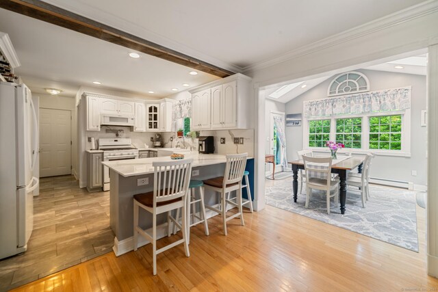 2 Bronson Rd, Prospect, CT 06712 - kitchen featuring white appliances, a peninsula, a breakfast bar area, light wood-style floors, and light countertops