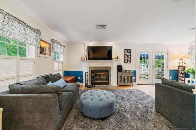 2 Bronson Rd, Prospect, CT 06712 - living area featuring ornamental molding, plenty of natural light, a tiled fireplace, wood finished floors, and french doors