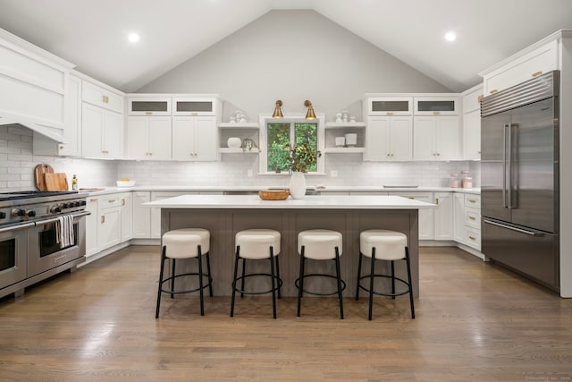 3663 Congress St, Fairfield, CT 06824 - kitchen with premium appliances, open shelves, a kitchen island, white cabinets, and a breakfast bar area